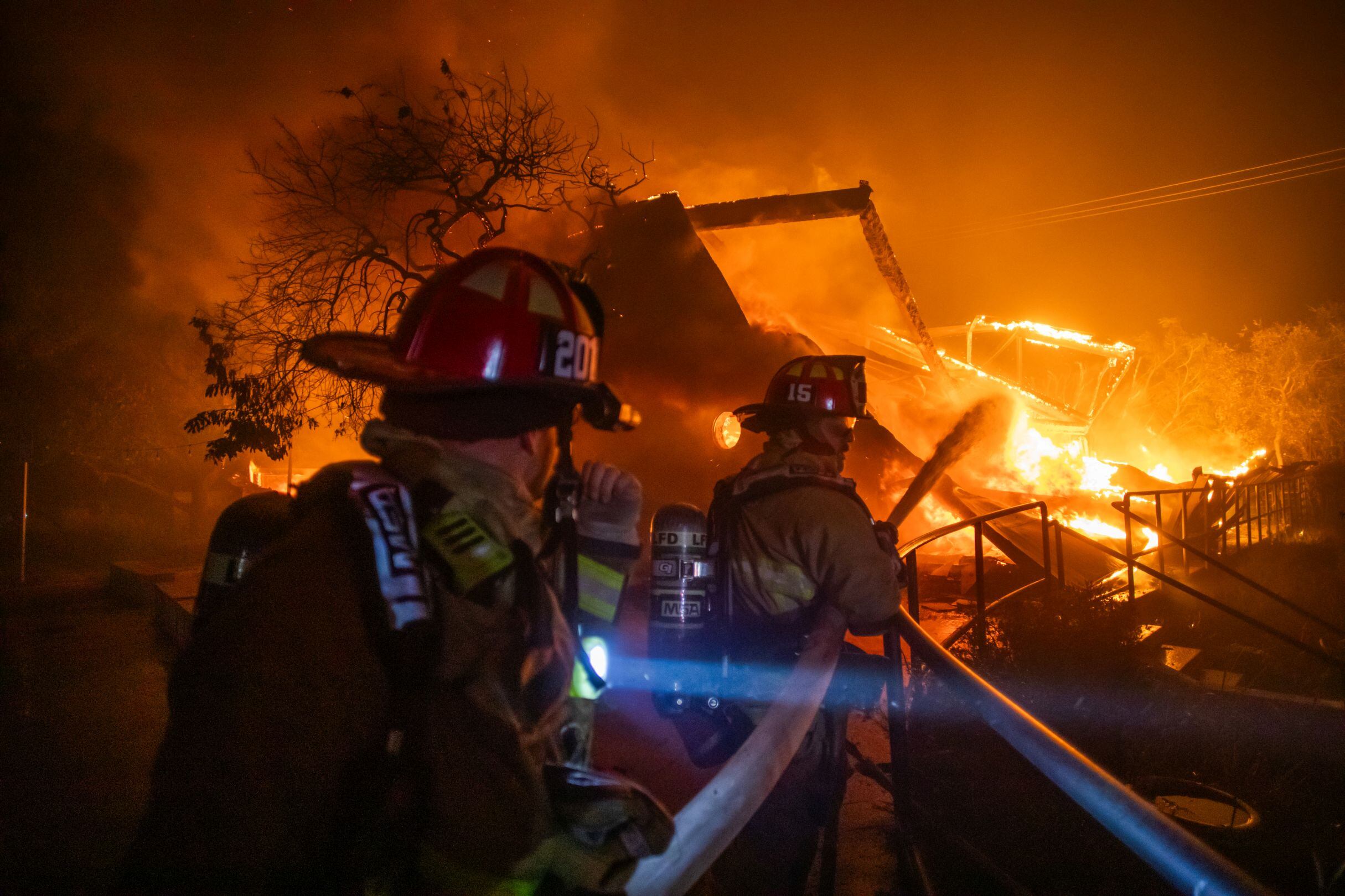 Los bomberos combaten las llamas del incendio Palisades que quema el Theatre Palisades durante una poderosa tormenta de viento el 8 de enero de 2025. (Foto: Apu Gomes / Getty Images)