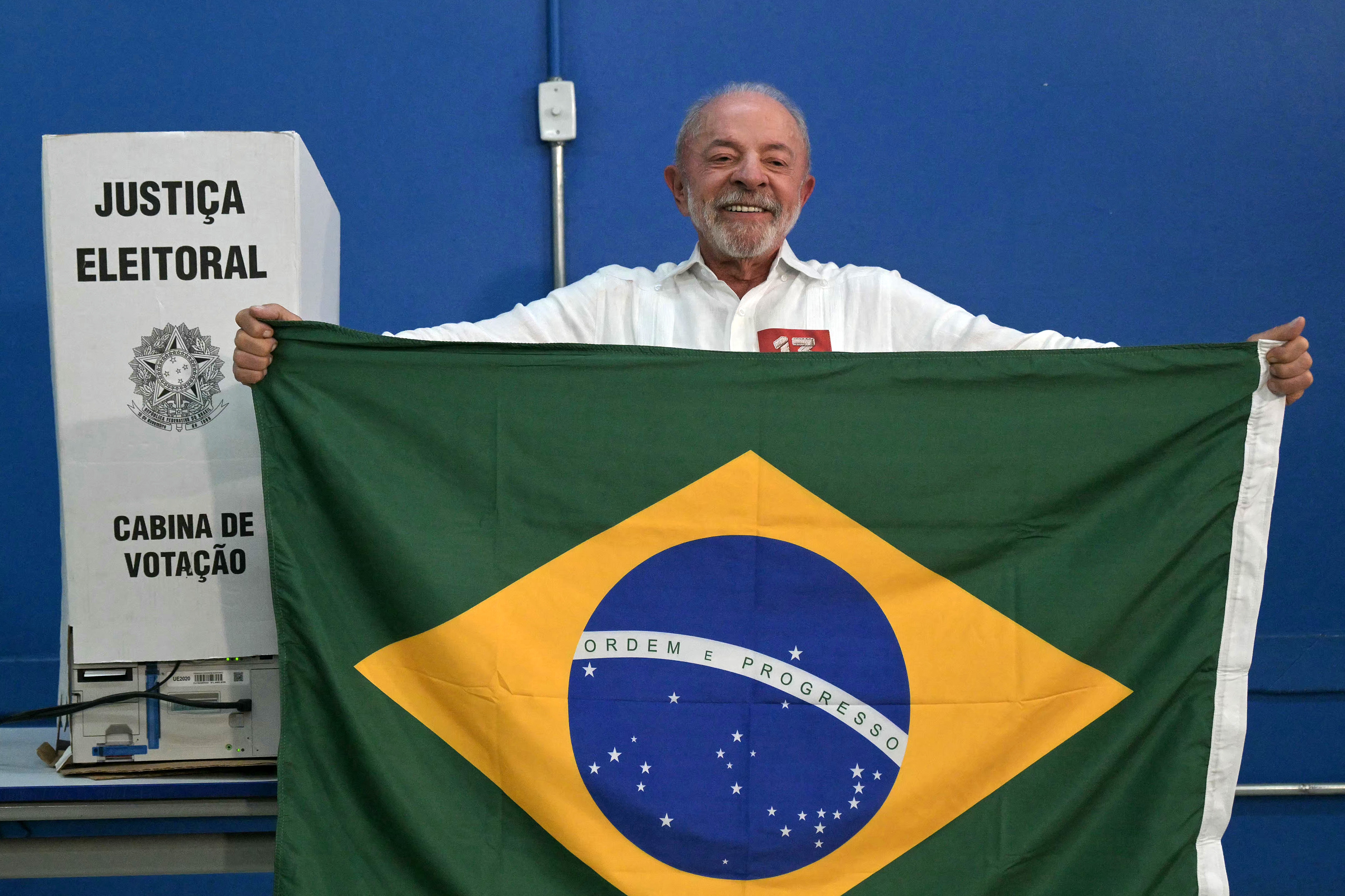 El presidente de Brasil y candidato a la reelección por el Partido de los Trabajadores (PT), Luiz Inácio Lula da Silva, sostiene una bandera brasileña tras votar en São Bernardo do Campo, estado de São Paulo, el 25 de octubre de 2026. (Foto de NELSON ALMEIDA / AFP).