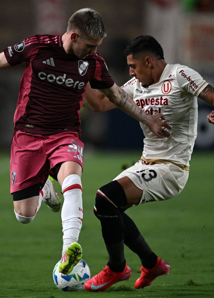 River Plate's midfielder #30 Franco Mastantuono (L) and Universitario's defender #33 Cesar Inga fight for the ball during the Copa Libertadores group stage first round football match between Peru's Universitario de Lima and Argentina's River Plate at he Monumental "U" Marathon stadium in Lima, on April 2, 2025. (Photo by ERNESTO BENAVIDES / AFP)
