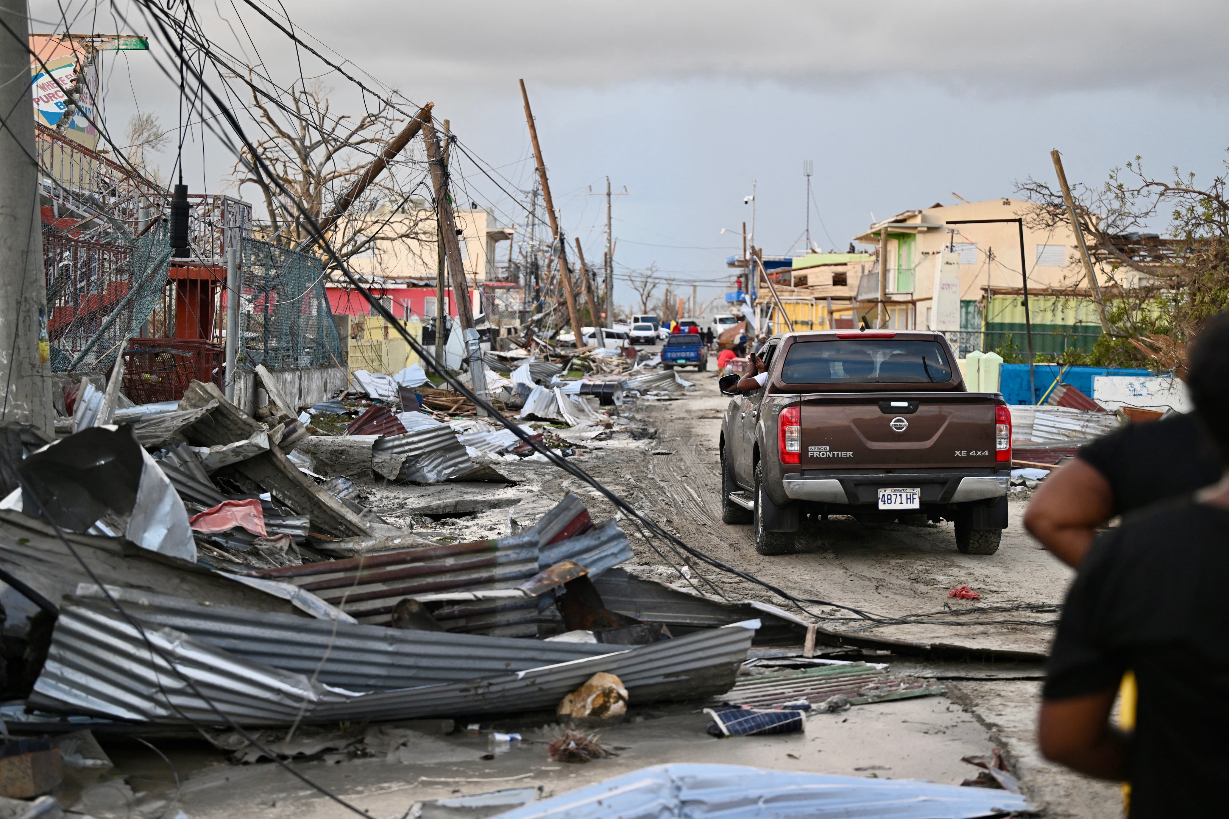 Un automóvil circula por un vecindario destruido tras el paso del huracán Melissa por Black River, Jamaica, el 29 de octubre de 2025. (Ricardo MAKYN / AFP).