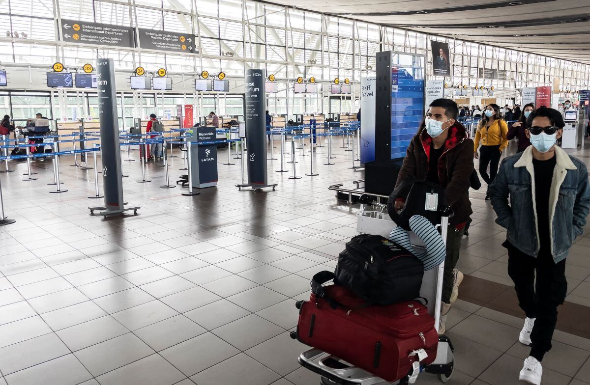 Los pasajeros caminan en el Aeropuerto Internacional Arturo Merino Benítez en Santiago el 1 de abril de 2021, luego de que Chile anunció que cerrará sus fronteras debido a la pandemia de coronavirus. (Martín BERNETTI / AFP).