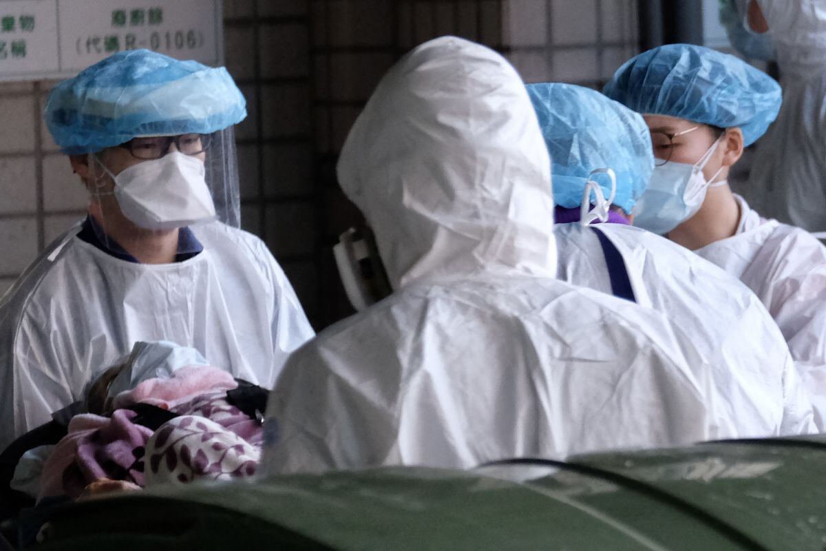 El personal médico enmascarado escolta a un paciente fuera del Hospital General de Taoyuan, donde se detectó un grupo de infecciones por coronavirus Covid-19, en Taoyuan, Taiwán, el 19 de enero de 2021. (Sam Yeh / AFP).
