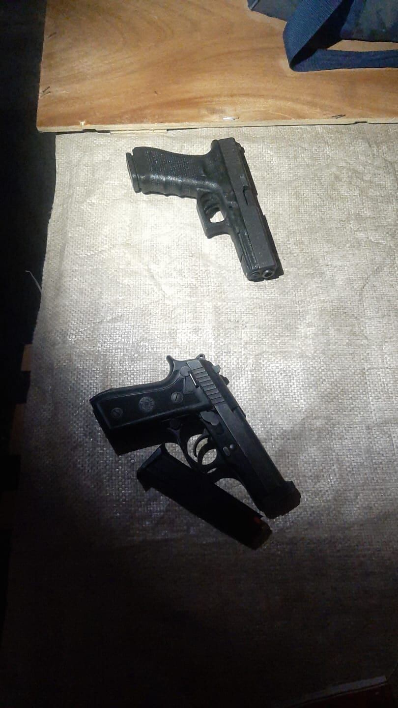 Aquí, la pistola que tenía el delincuente junto al arma del vigilante.