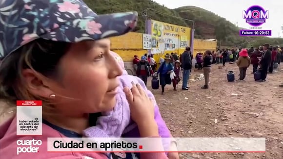 Cusco: Mujer con bebe en brazos sobre cola para comprar un balón de gas