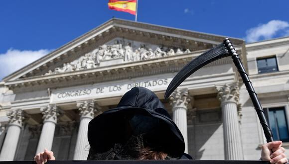 Un manifestante vestido como la Muerte se manifiesta contra una ley que legaliza la eutanasia en Madrid el 18 de marzo de 2021 mientras el Parlamento da la aprobación final al proyecto de ley que despenaliza la eutanasia y el suicidio asistido por un médico. (Foto de JAVIER SORIANO / AFP)