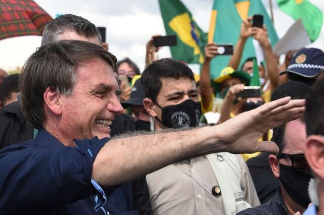 El presidente de Brasil, Jair Bolsonaro, saluda a simpatizantes de su partido al llegar al Palacio de Planalto en Brasilia, en medio de la pandemia del coronavirus COVID-19. (AFP / EVARISTO SA)