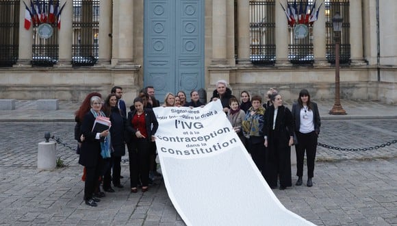 Miembros del parlamento del partido izquierdista francés La France Insoumise (LFI) y miembros de asociaciones a favor del aborto celebran con una pancarta después de que el parlamento votara para agregar el derecho al aborto a la constitución, frente a la Asamblea Nacional en París el 24 de noviembre de 2022. (Foto de Geoffroy Van der Hasselt / AFP)