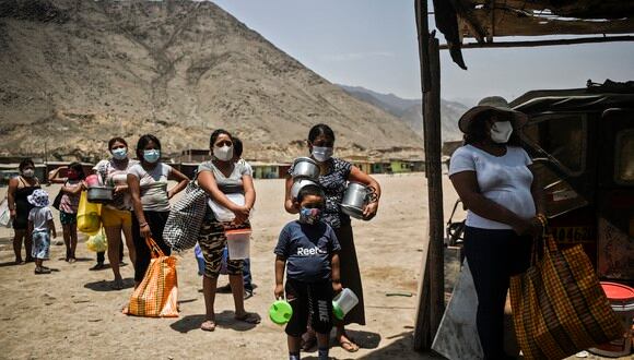 Foto de personas mantienendo distancia de seguridad mientras esperan recibir alimentos en un comedor de beneficencia en Comas, Lima, en medio de la pandemia de coronavirus. (Foto: ERNESTO BENAVIDES / AFP)