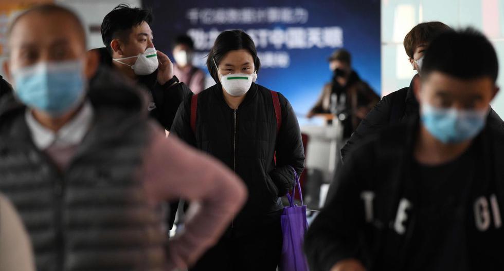Imagen referencial. Los pasajeros usan mascarilla como medida preventiva contra el coronavirus cuando llegan de un vuelo en el Aeropuerto de Beijing. (AFP).