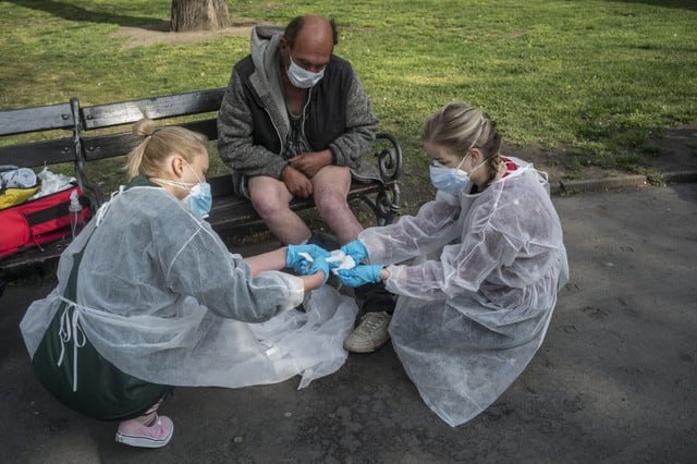 Médicos de la Facultad de Medicina de la Universidad de Charles tratan a las personas sin hogar frente a la estación de tren principal de Praga, en medio de restricciones debido a la nueva pandemia de coronavirus (COVID-19). (Michal Cizek / AFP)