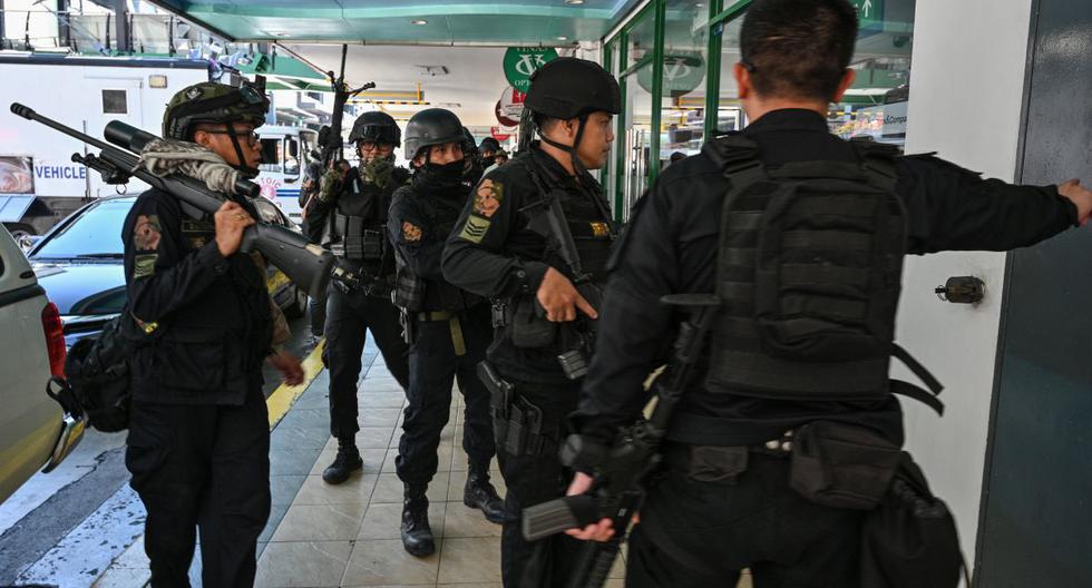 Miembros del equipo SWAT de la policía toman posiciones fuera de una de las entradas de un centro comercial después de que se informó de una situación de rehenes en los suburbios de Manila. (AFP)